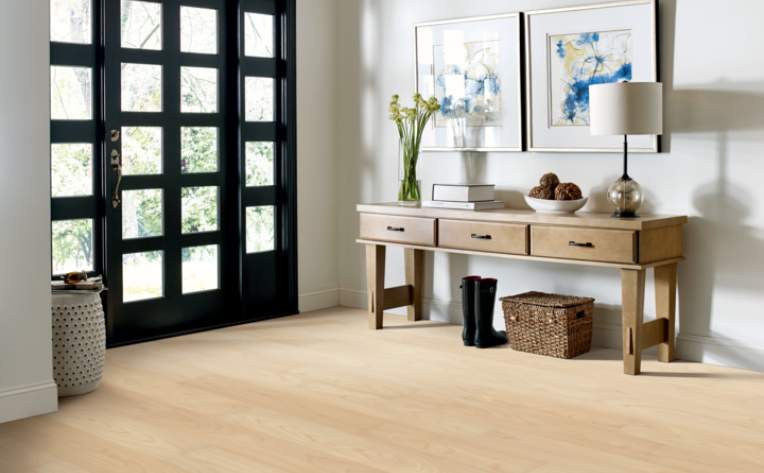 light luxury vinyl flooring in entryway with wood table and black door